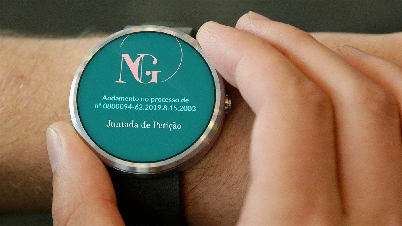 Smartwatch no pulso exibe o monograma NG e a notificação: Andamento no processo de nº 0800094-62.2019.8.15.2003, Juntada de Petição