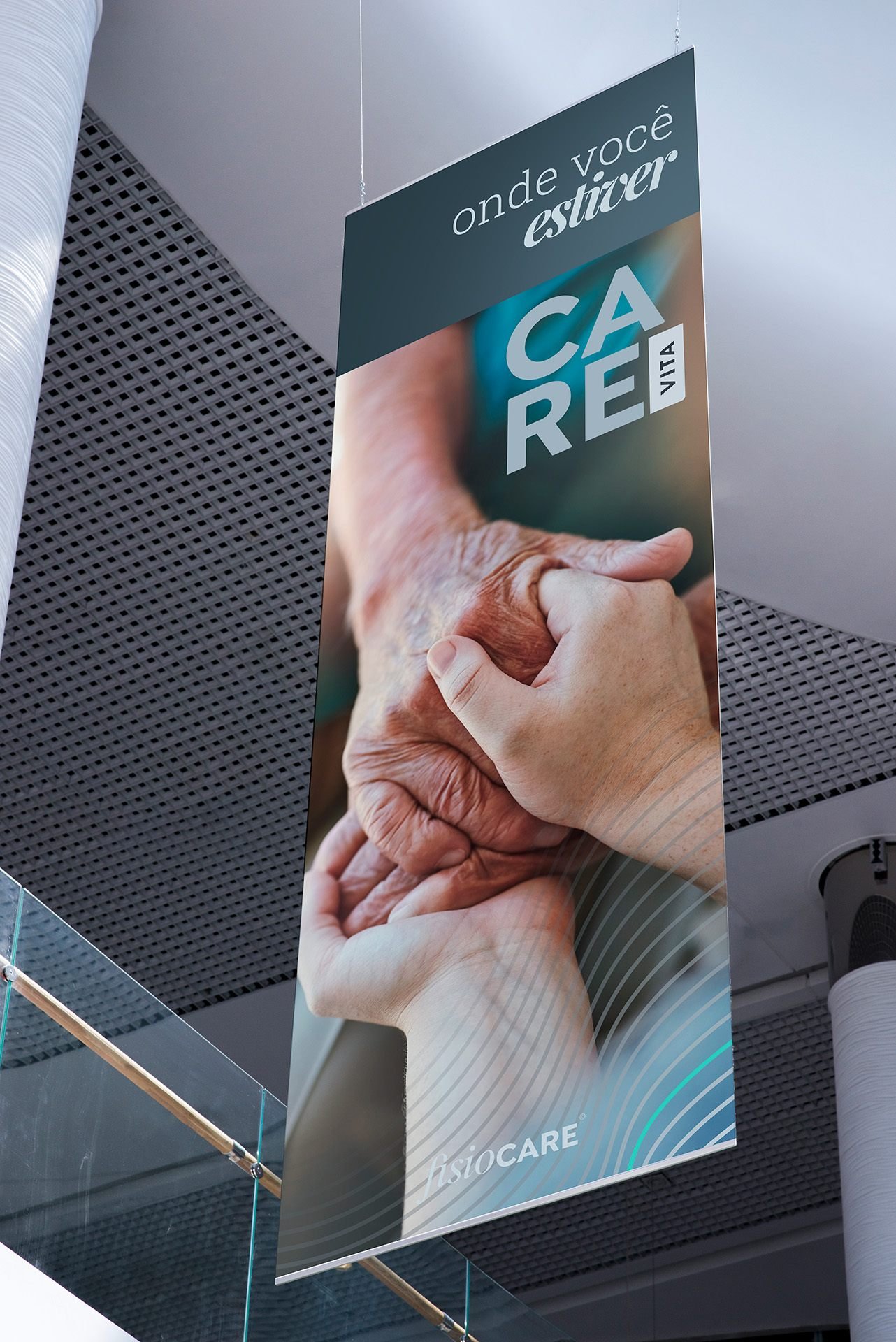 Banner suspenso num vão de escada com a marca CARE Vita, mãos dadas e a frase onde você estiver